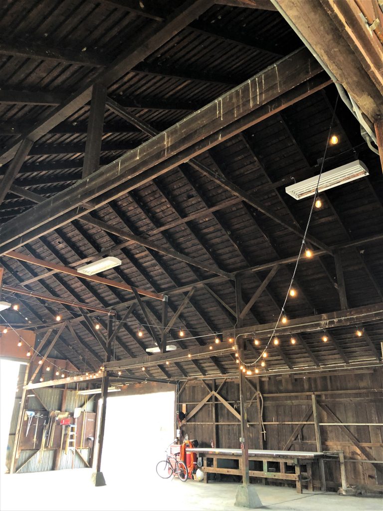 Abele Farms, Yolo County, Inside old barn. Rafters and beams with hanging lights.